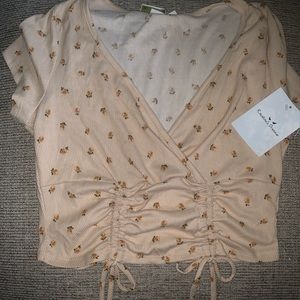 Light tan short sleeve crop top with flower details